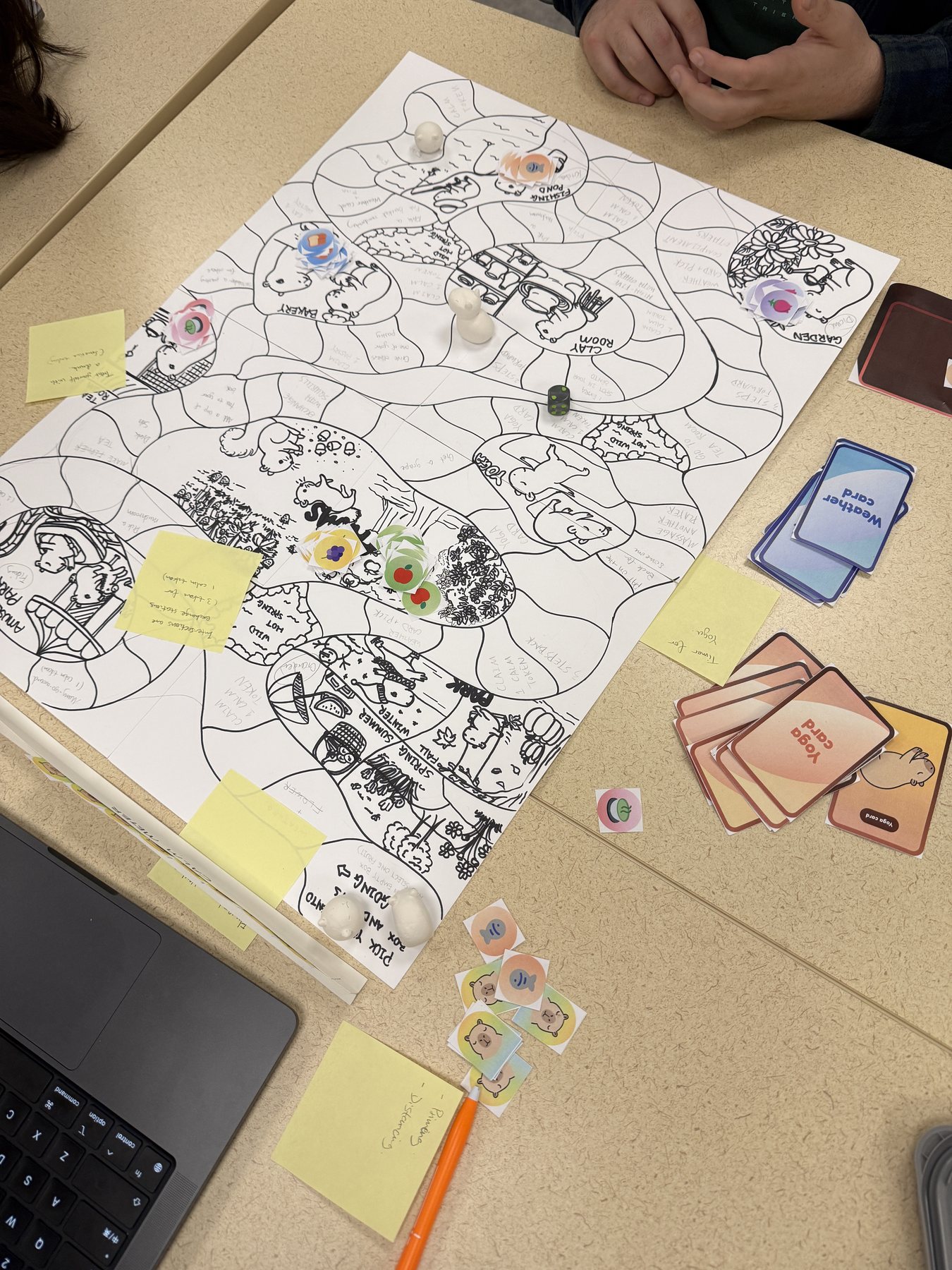Black-and-white first playable Capybara Land prototype with handwritten tiles, paper cards, tokens, and notes