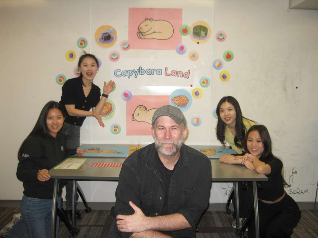 The Capybara Land team with instructor Geoff Kaufman beside the final project display