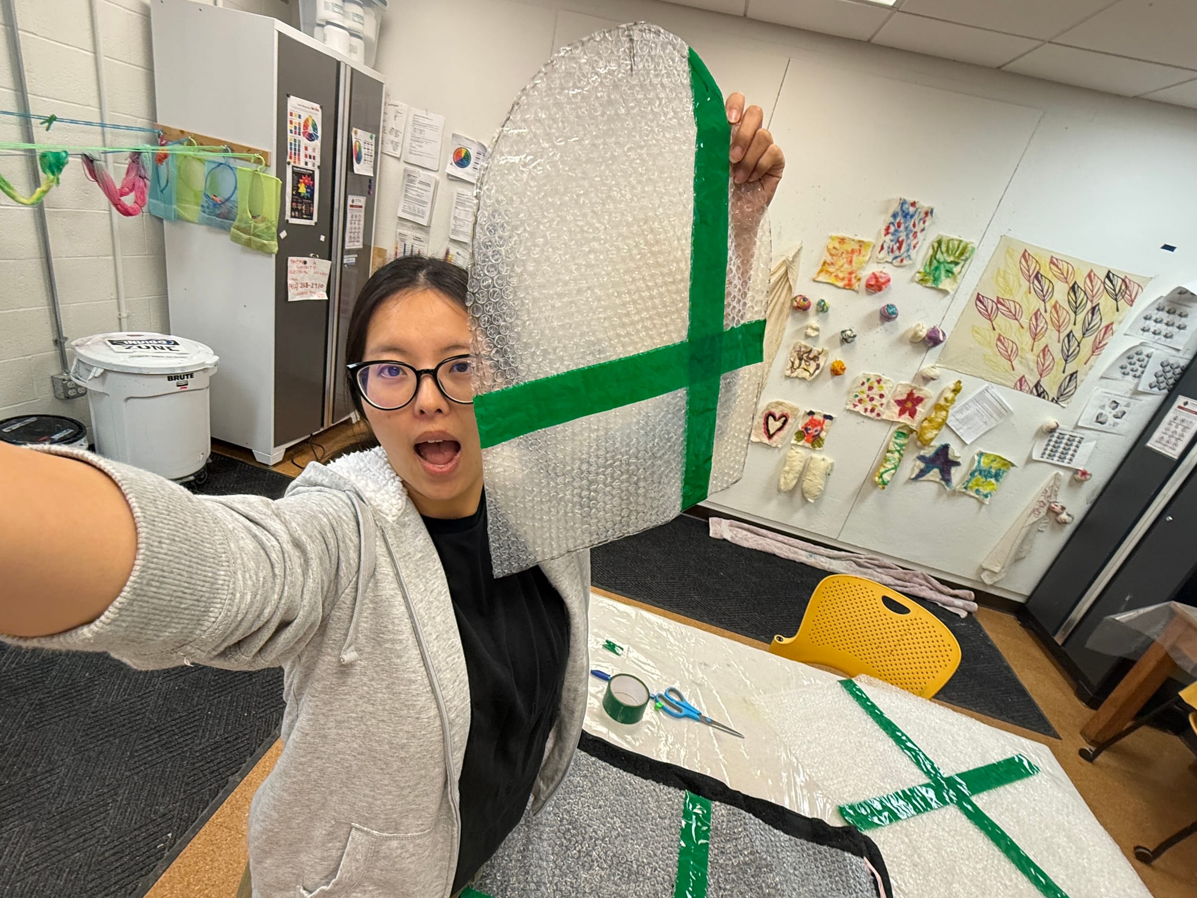 Yazmin holding the enlarged resist template used to make the felt hat