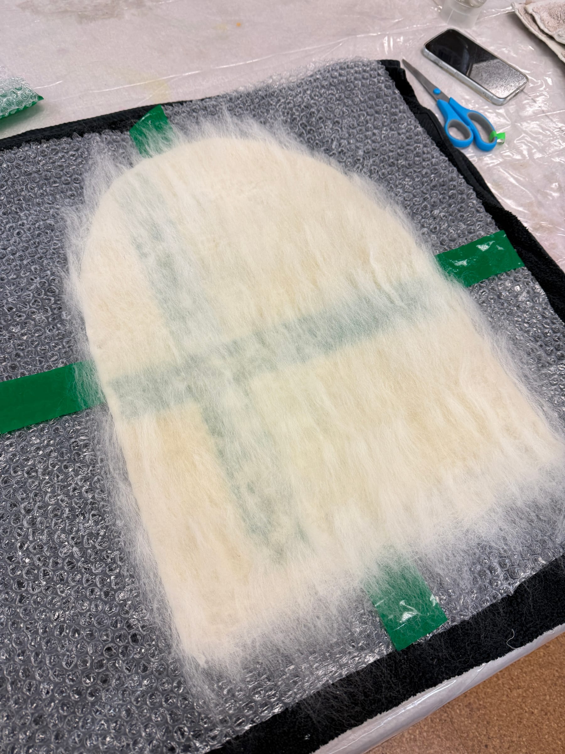 White wool fibers laid in overlapping layers over the resist