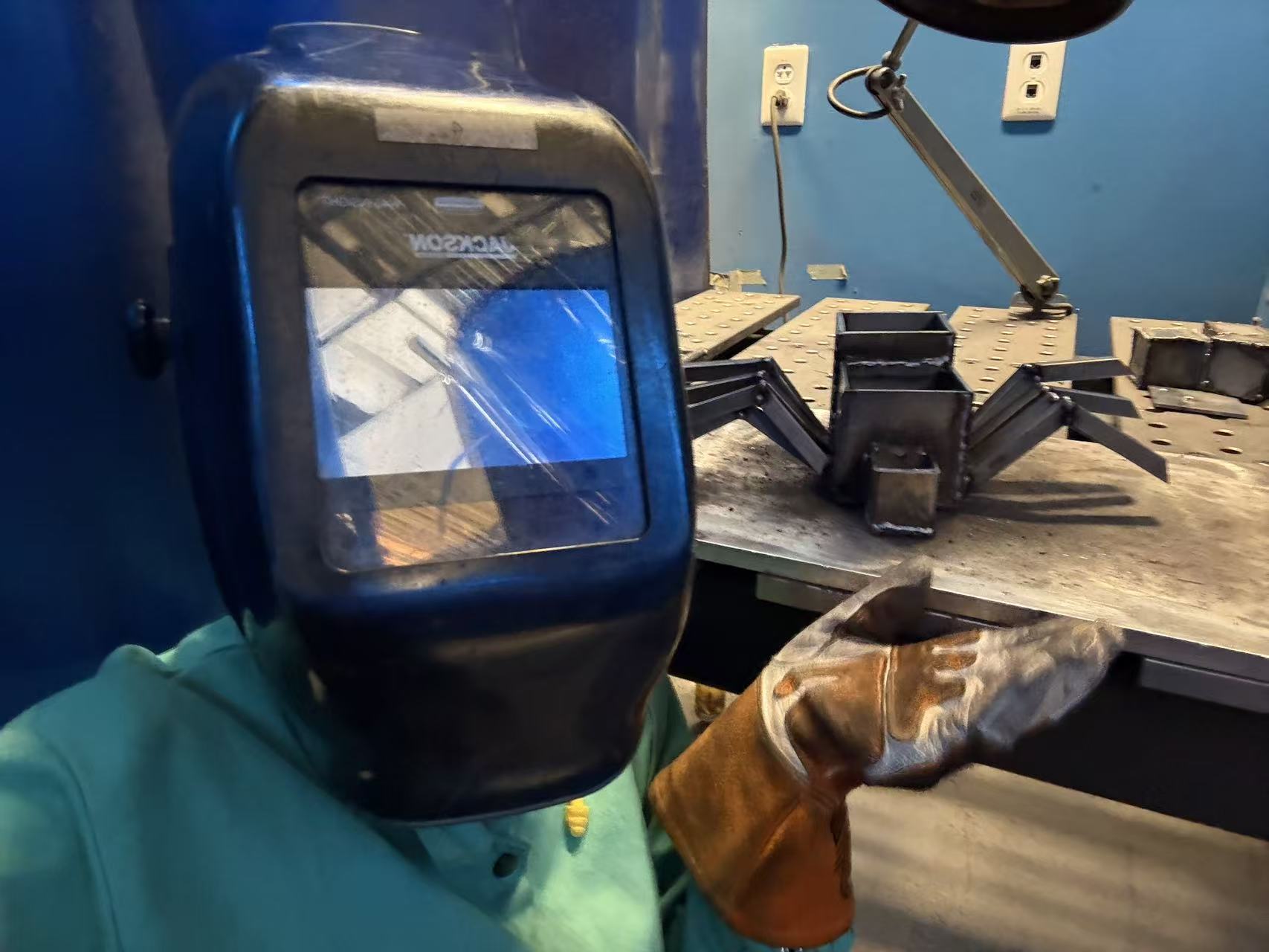 The welded spider form on a workshop table